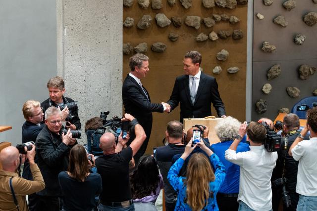 Minister of Finance Eelco Heinen shakes hands with President of the House Martin Bosma in front of the press.